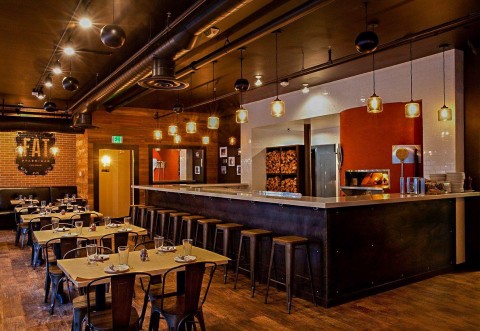 Warm and rustic dinning area of Fat Ptarmigan with wood fire oven behind the bar