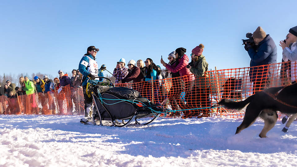 Musher glides past the crowd gathered in Willow to watch the official start of the Iditarod