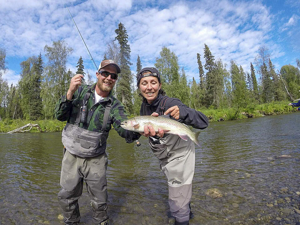Guide and angler hold a fish while fishing at Wilderness Place Lodge