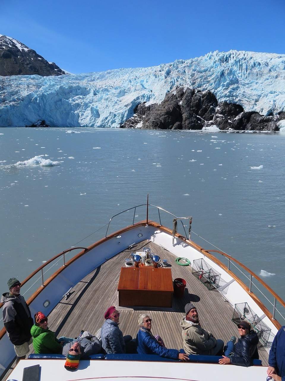 Passengers aboard the M/V Sea Star powered by luxury yacht company North Pacific Expeditions linger in front of a tidewater glacier
