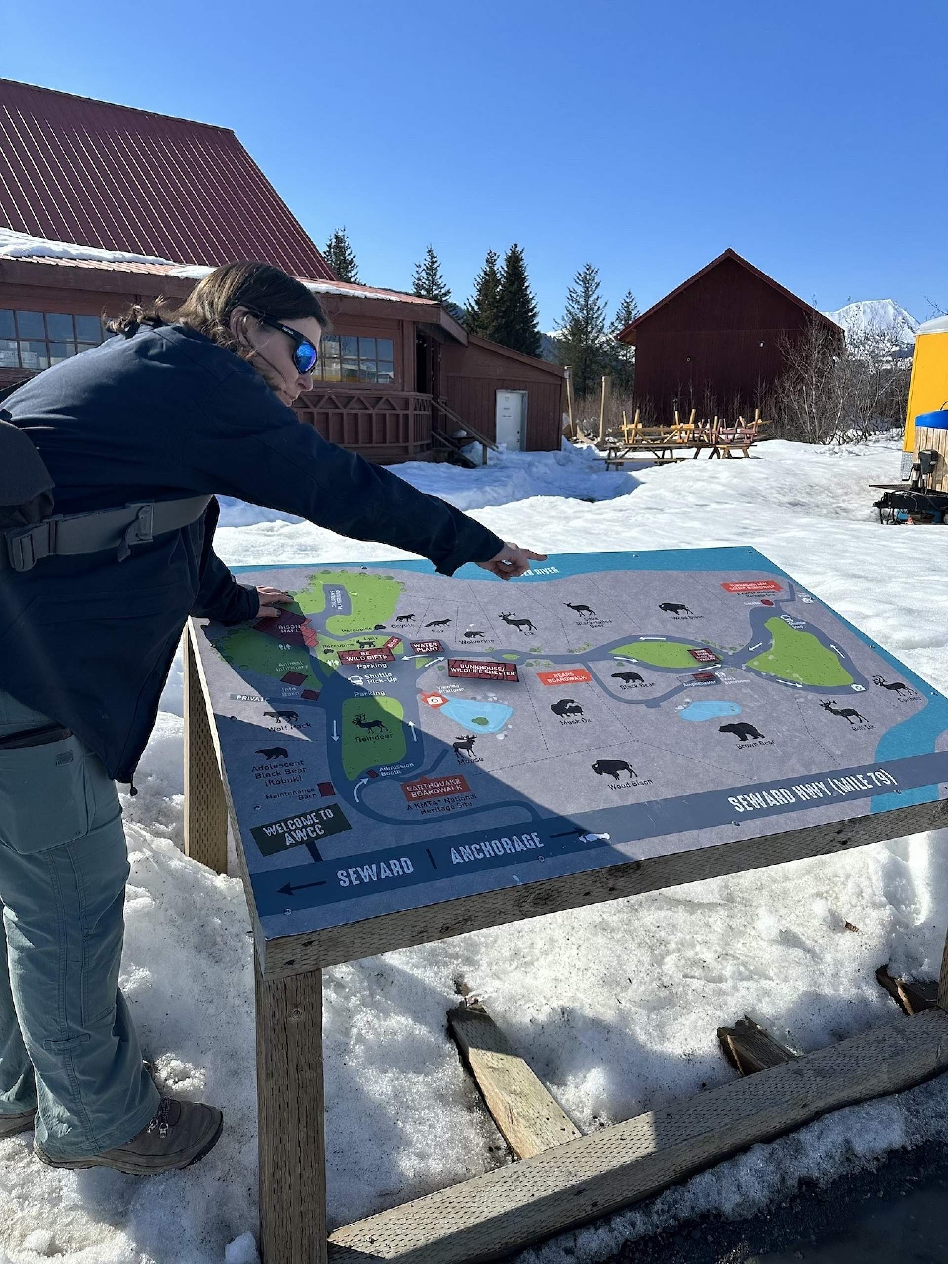 Wildlife guide and expert pointing to a sign at the Alaska Wildlife Conservation Center.