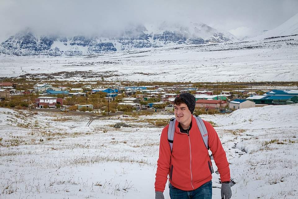 Alexyn Scheller in Gates of the Arctic National Park with the village of Anaktuvuk Pass behind him