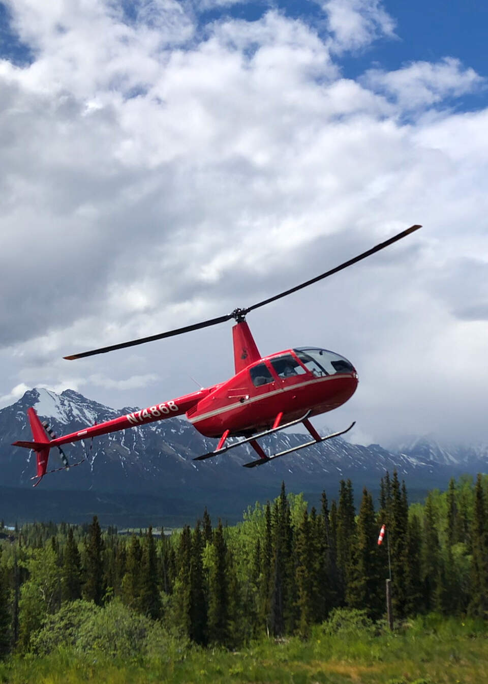 Red helicopter lands to pick up passengers