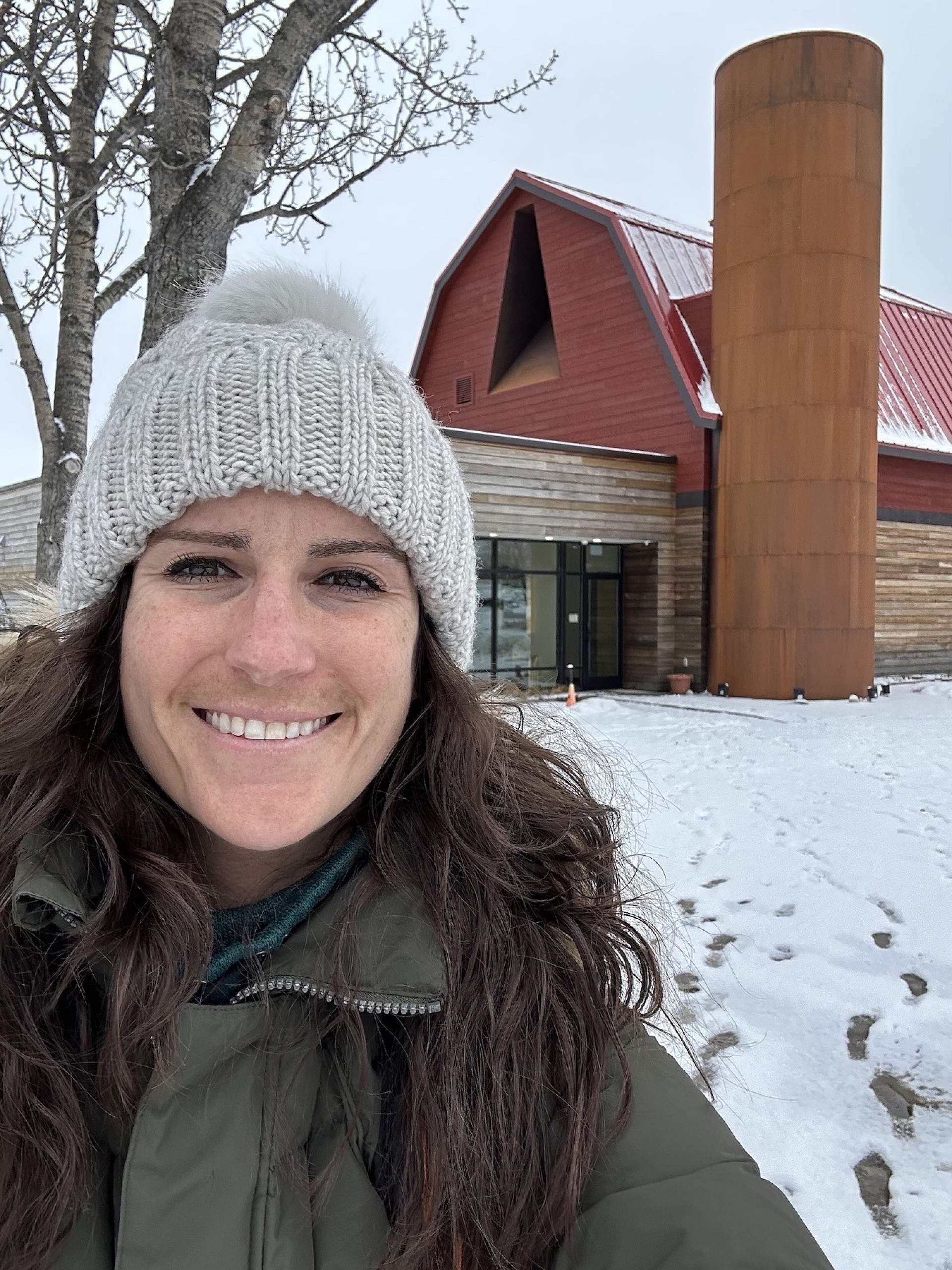 Jaime Hammond poses in front of the visitor center at the Musk Ox Farm in Palmer, Alaska