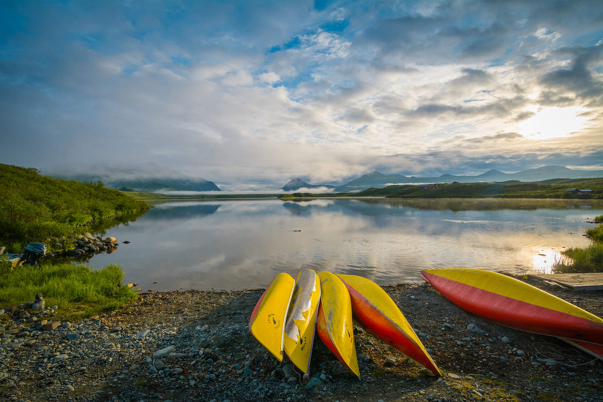 A row of canoes line a lake in Alaska.