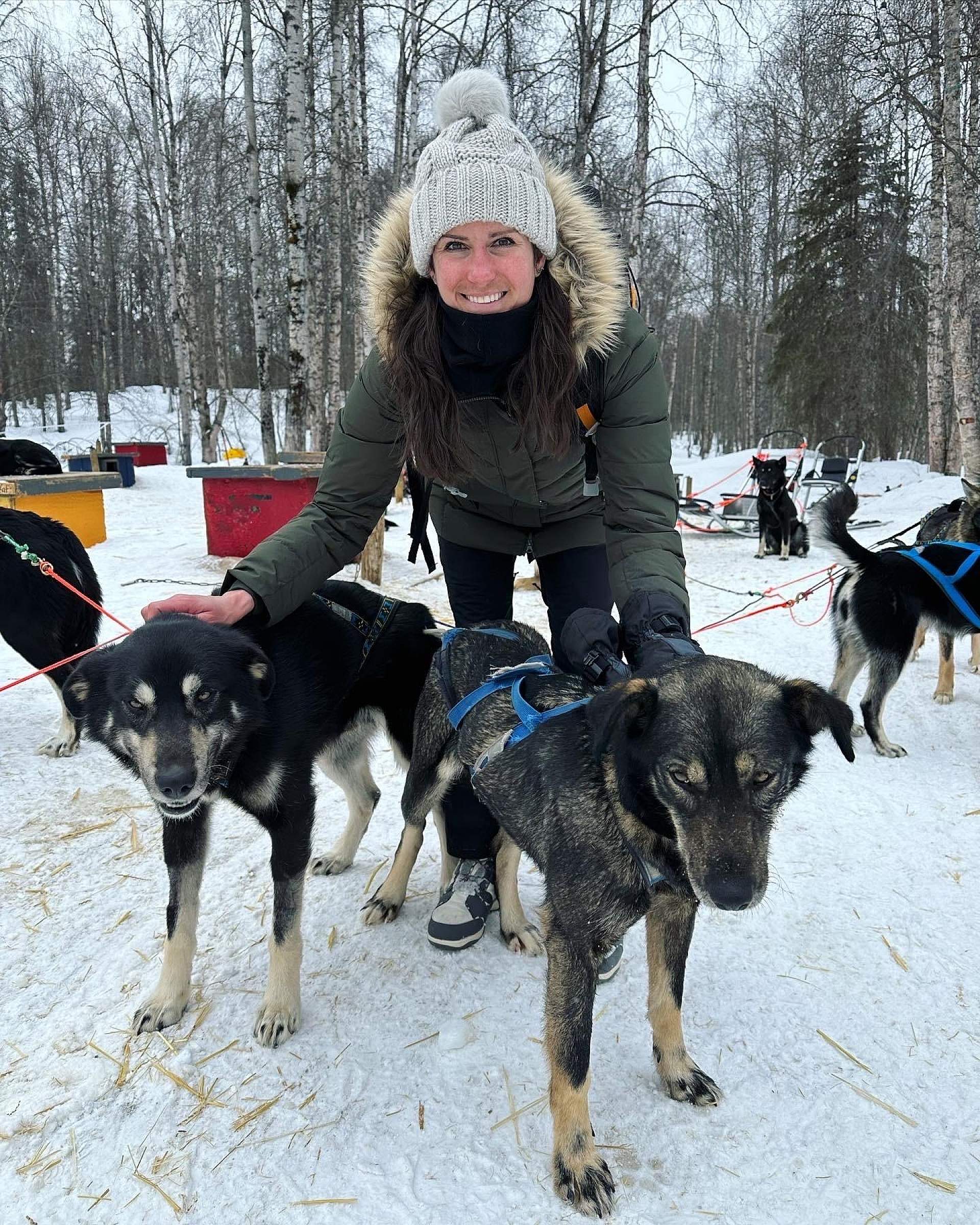 Jaime pets the two lead dogs on a dogsledding tour at Snowhook Adventure Guides of Alaska.