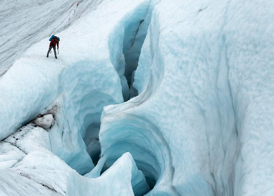 Ice climber looking into moulin