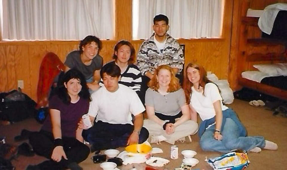 Bunkhouse banter—cards on a milk crate, laughter bouncing off metal bunks.