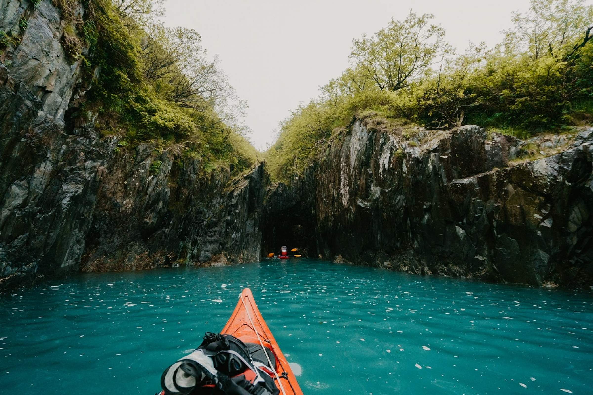 Kayaker paddles close to shore in Kenai Fjords National Park