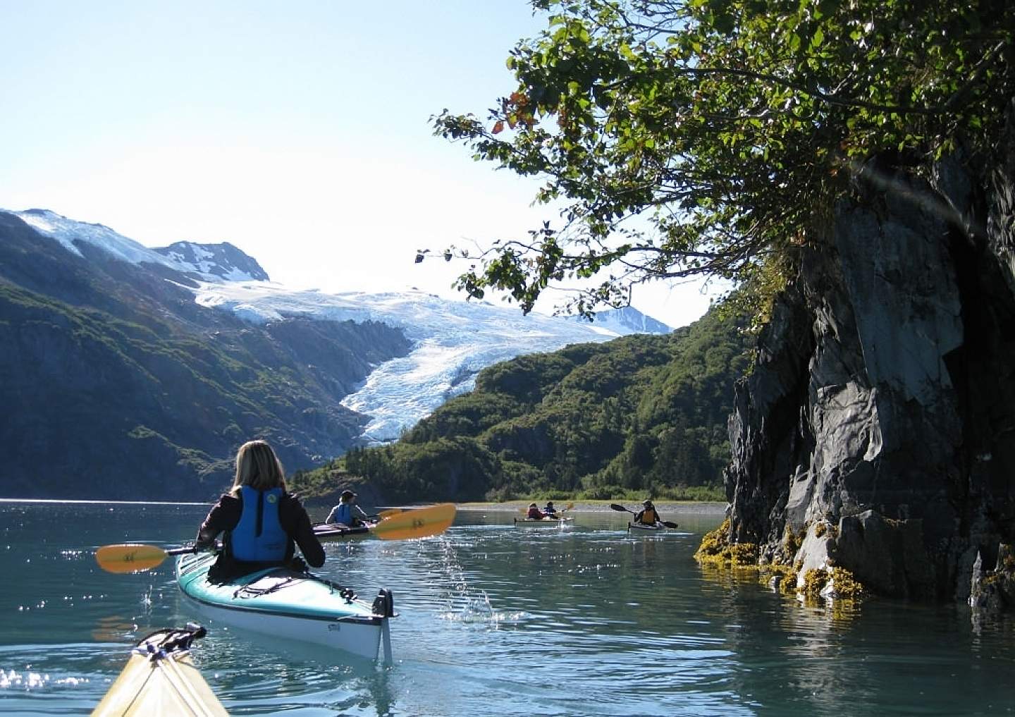 People kayaking in Prince William Sound near a glacier