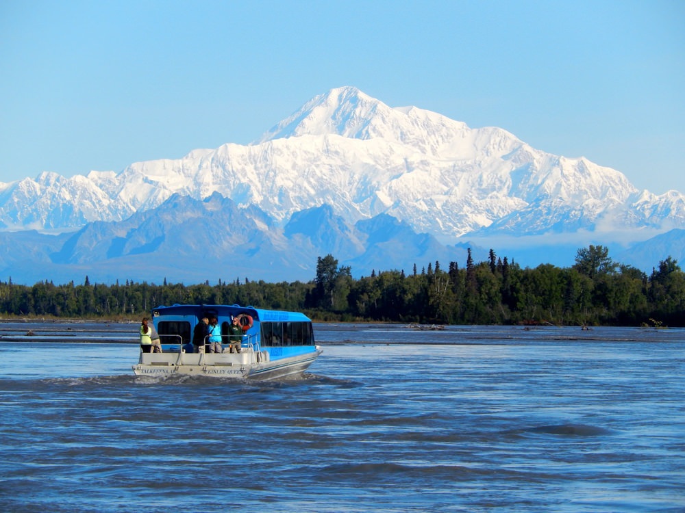 A jetboat on the water with Mt. Denali in the background.