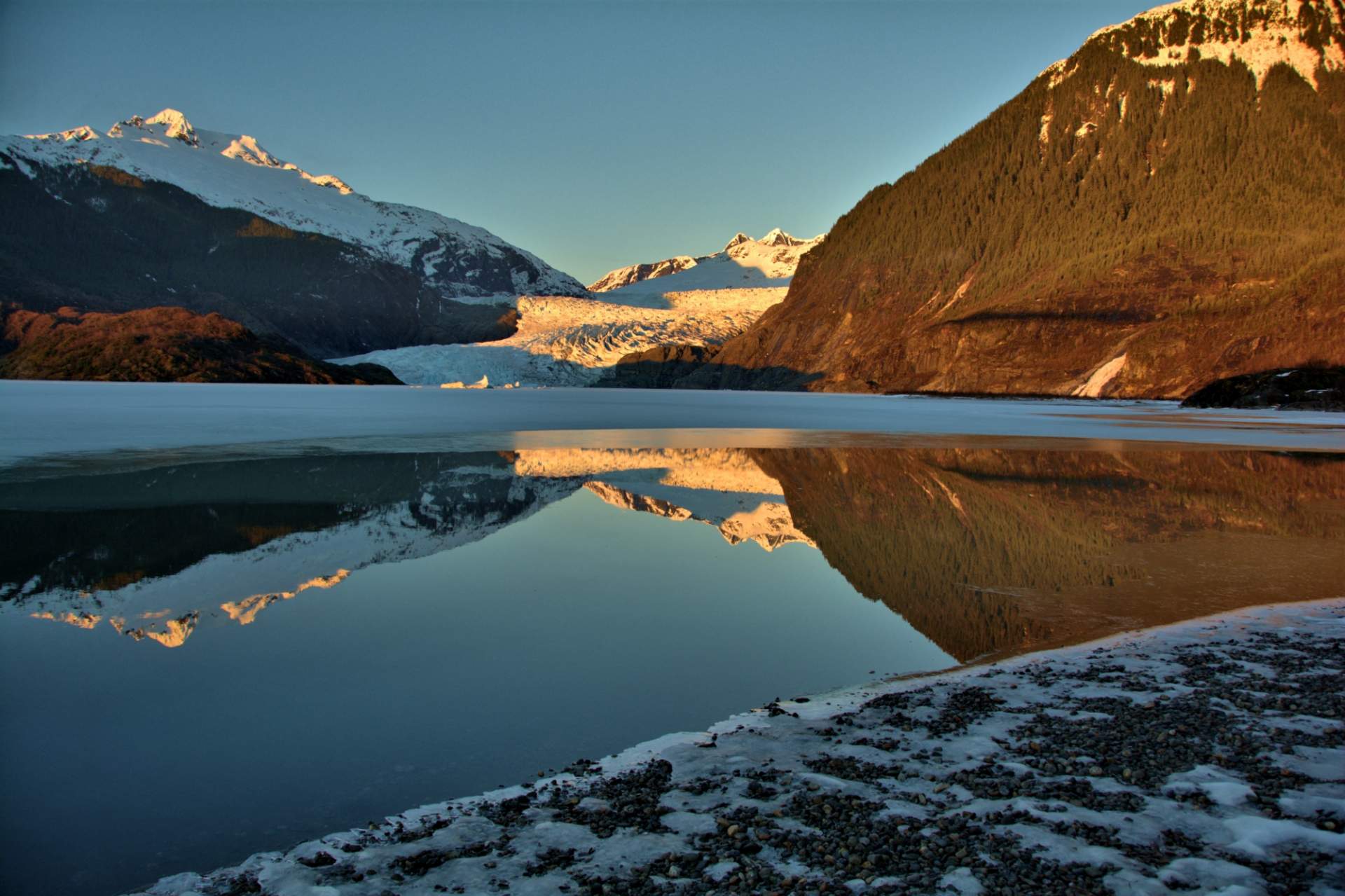 Mendenhall Glacier with an alpine glow and reflecting on the water