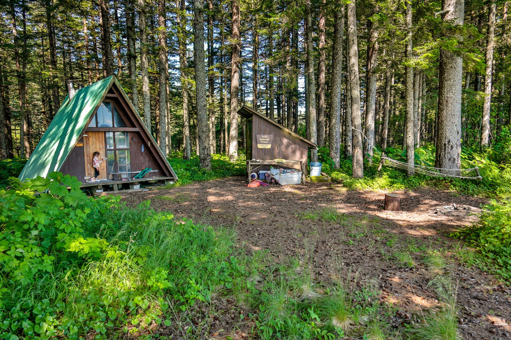 A small A-frame cabin in the woods.