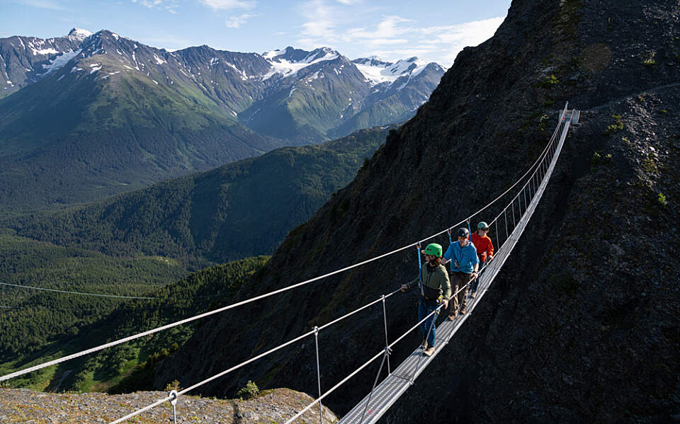 Strapped in with a harness and helmet, adventurers take in jaw-dropping views from the Veilbreaker Skybridges—suspended 2,500 feet above the valley floor at Alyeska Resort.