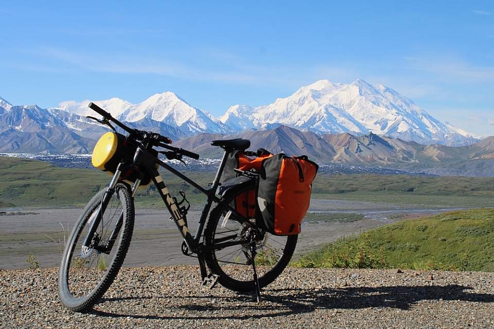 A bike is parked on the Denali Park Road with a view of Mt. Denali in the background