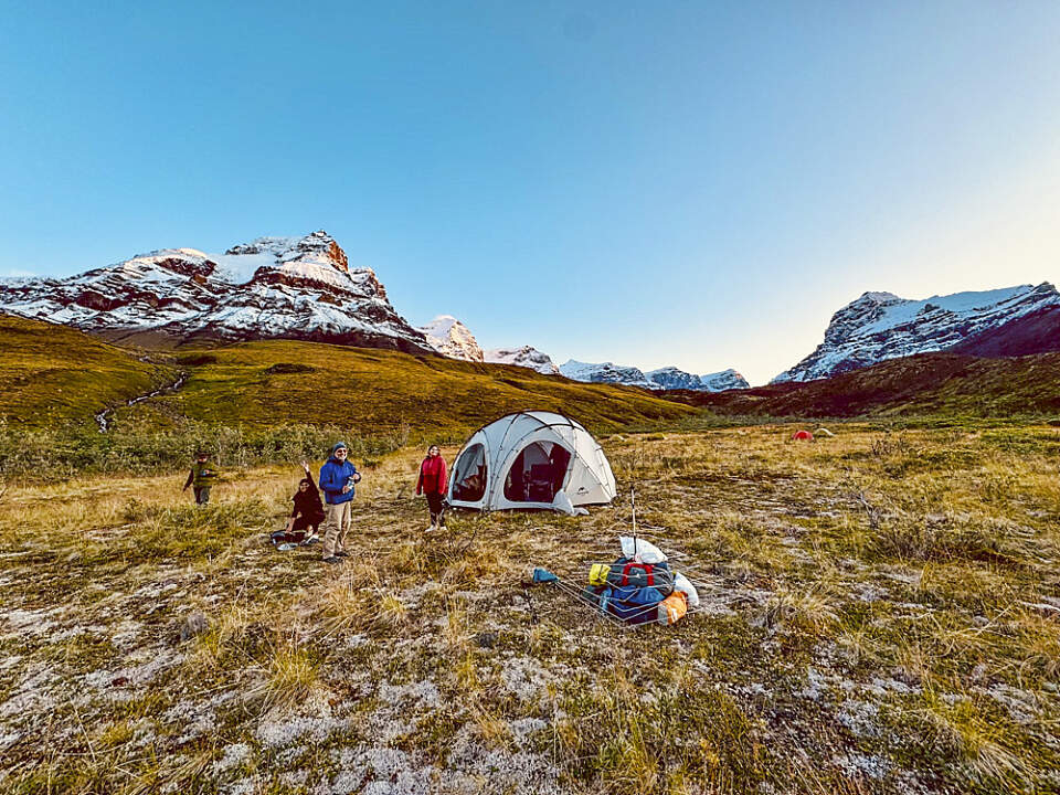 Guests gather around the main tent on the Wrangell St. Elias Basecamp Adventure