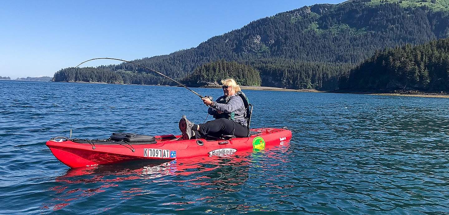 A woman fishes from a kayak.