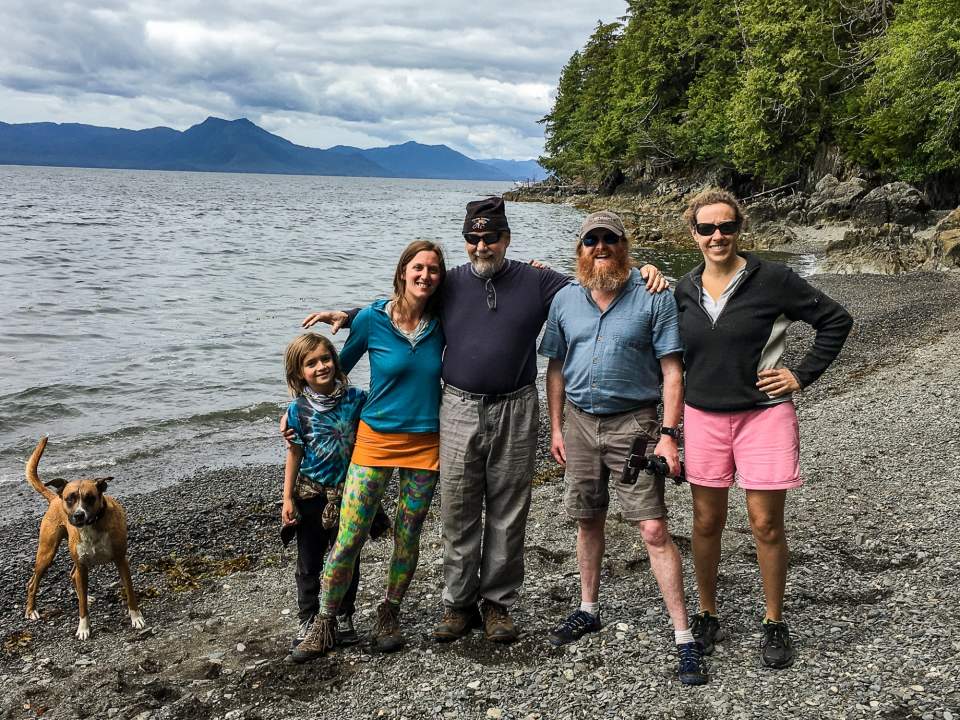 Owner Teague Whalen and others pose on a rocky Alaskan beach.