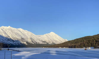 Moose pass adventures Bright Blue Sky and Snow White Mountains over Trail Lake in Moose Pass near Seward Alaska JD Boyle