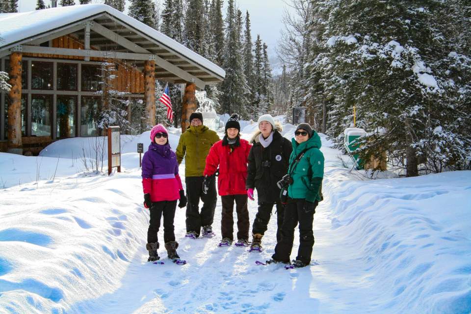 People in winter gear stand in front of the Murie Science and Learning Center.