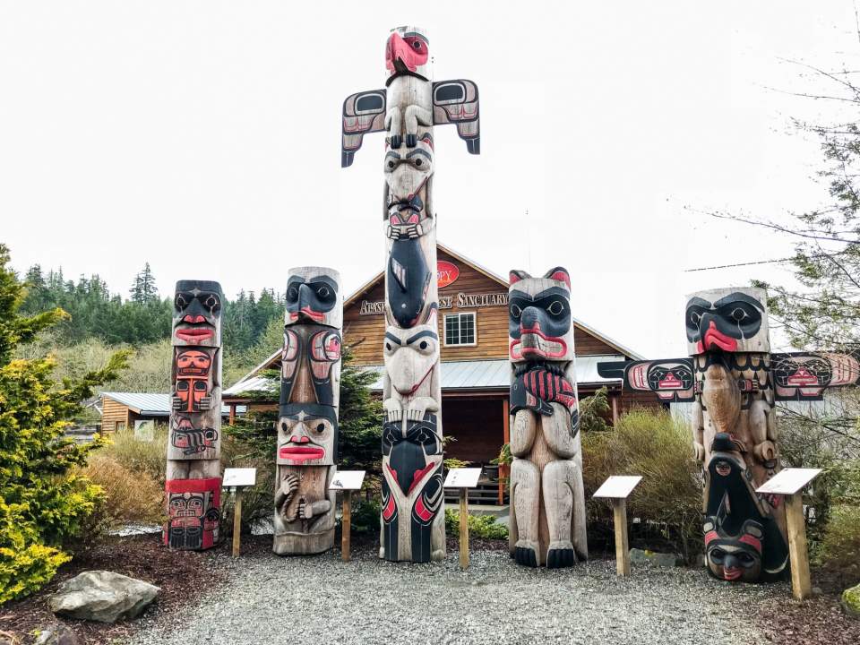 Totem poles displayed in a courtyard.