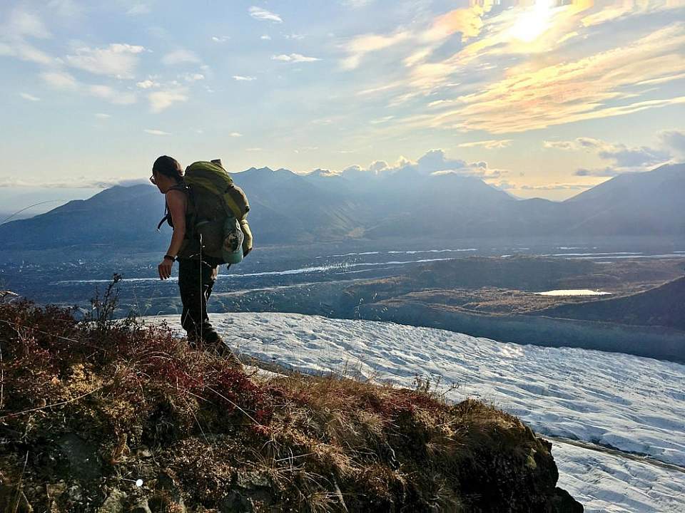 Two backpackers trek through a mountain pass.