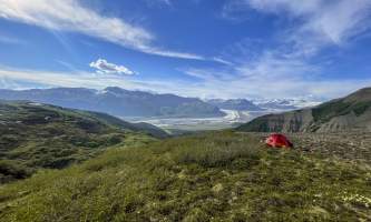Red tent set up on high overlook of a massive valley glacier and mountains Anya Voskresensky 2