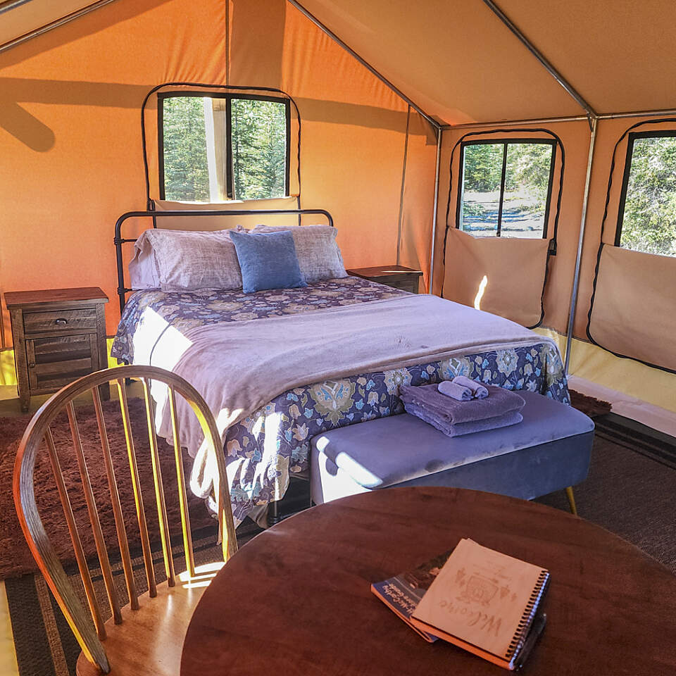 Inside your cozy tent, you’ll find a plush queen-size bed with an ultra-warm down comforter, thick blankets, hot water bottles for crisp nights, and large screened windows that fill the space with natural light and fresh air.
