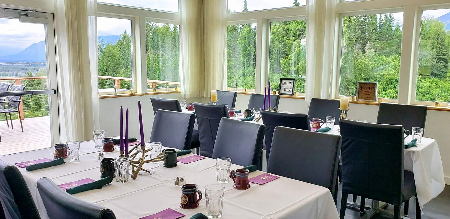 Dining room of Raven's Perch Restaurant with large windows letting in lots of natural light.