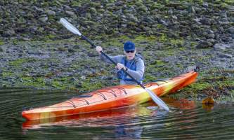 The lodge at whale pass Dad pushing off from shore in kayak Lucas Ryter