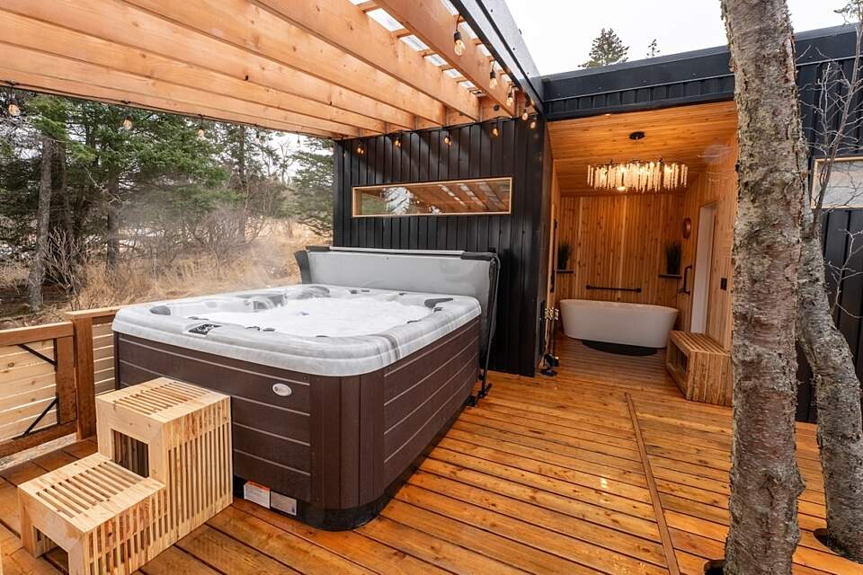 View of hot tub, cold plunge, and sauna entrance at the WestWind Cabins nordic-style spa