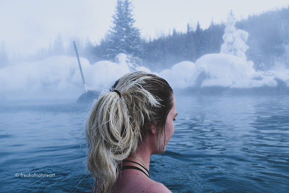 Woman soaks in Chena Hot Springs, Alaska with frosted hair from subzero temperatures