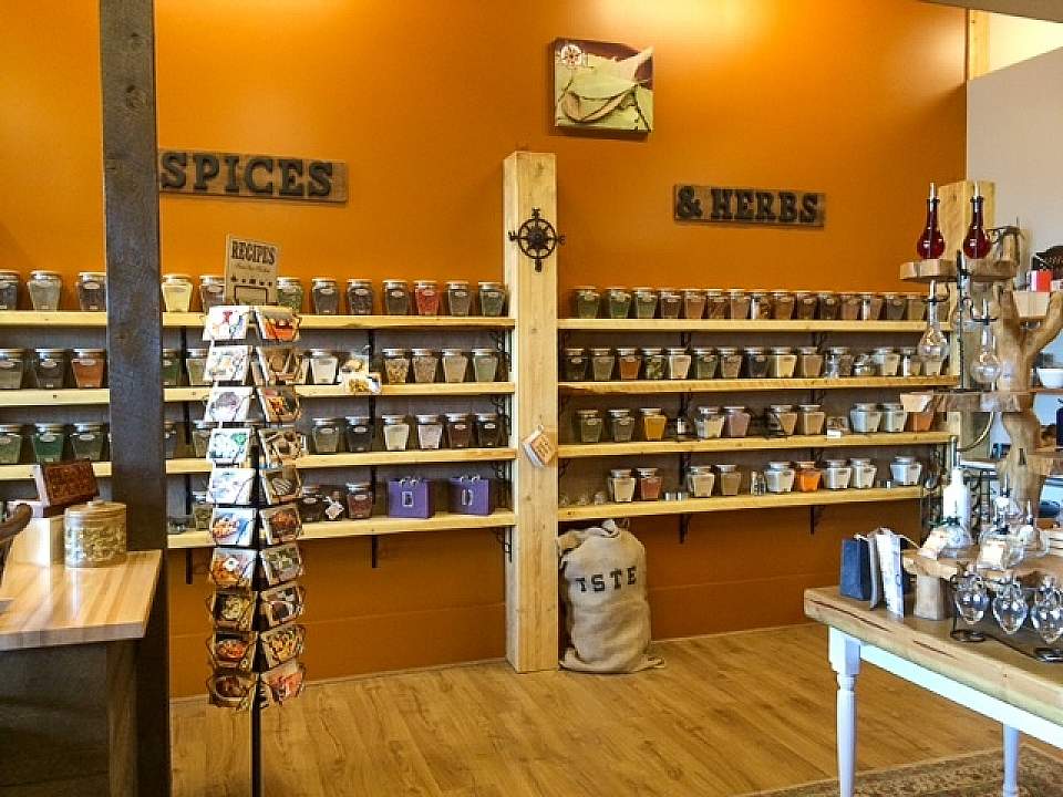 A shelf lined wall filled with jars of spices and herbs.